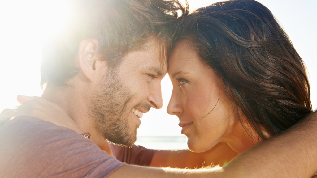 Couple improves intimacy by embracing outdoors with foreheads touching, symbolizing emotional closeness, vulnerability, and reconnection in couples therapy.